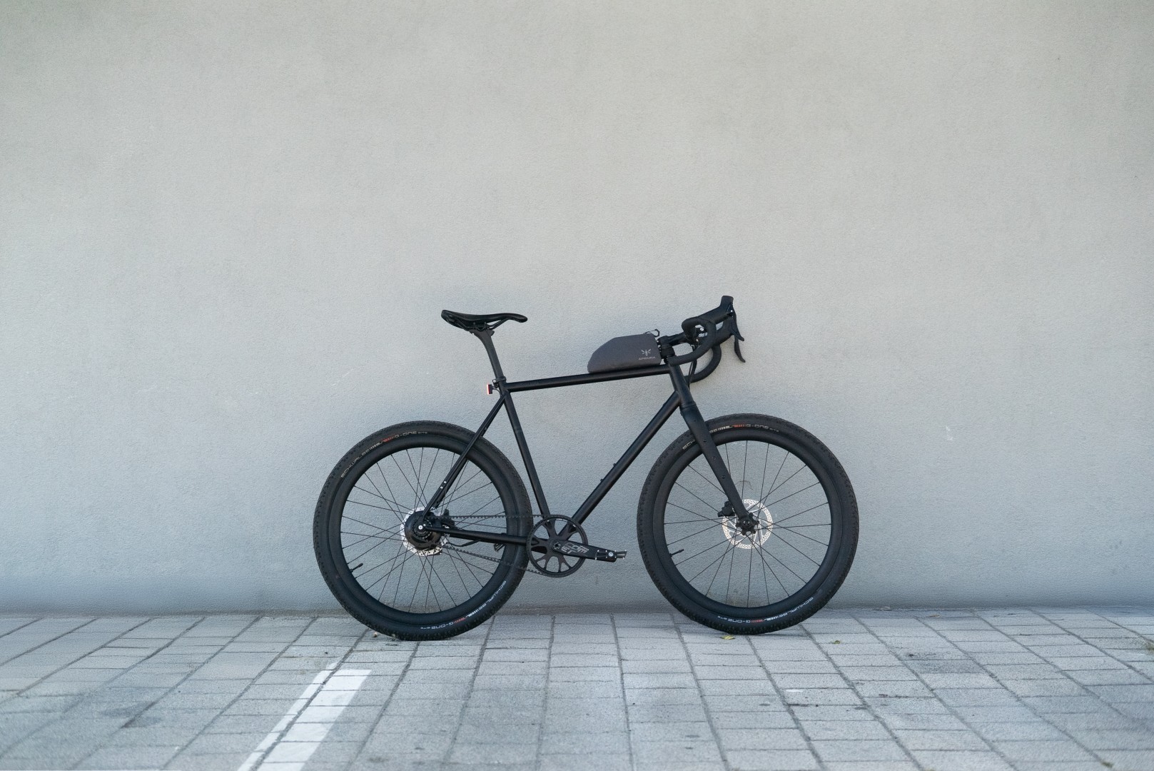 Booda Bike Alpine 3x3 gravel bike leaning against a grey wall