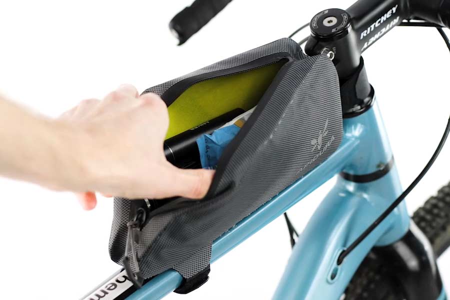 Åbning af lynlåsen med én hånd på Apidura Expedition Top Tube Pack