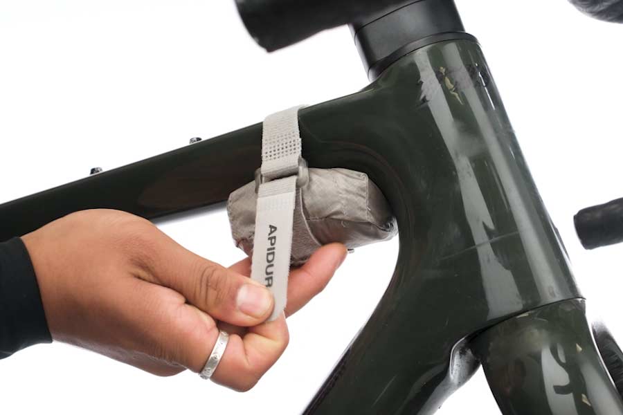 Apidura sammenpakkelig musette pakket ned i sin lomme og spændt fast på cyklens ramme