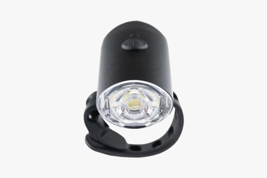 Booda Bike Glow front light seen head-on: a white front lens inside a black round body with a black silicone strap looped beneath it