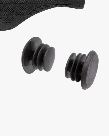 Two black bar end plugs with ribbed stems beside the edge of the patterned surface of an Ergo grip