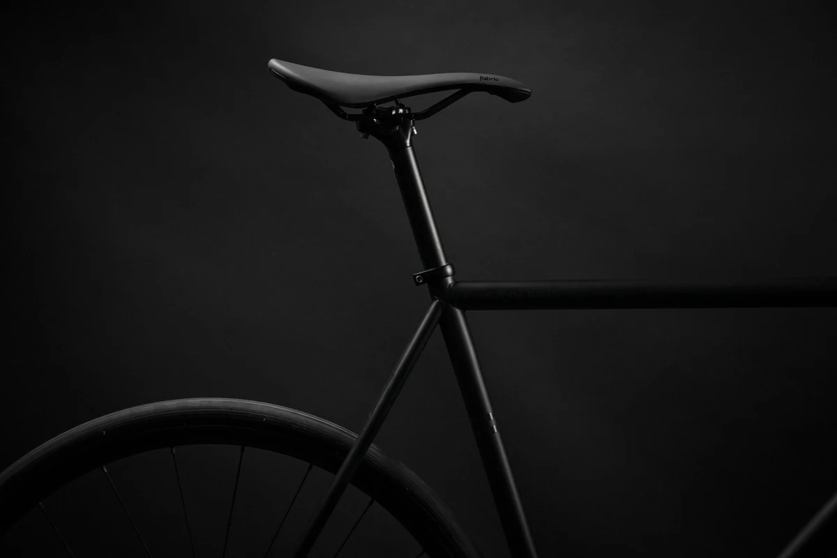 Booda Bike Astro in a dark studio with the saddle on a slim seat post above the seat tube