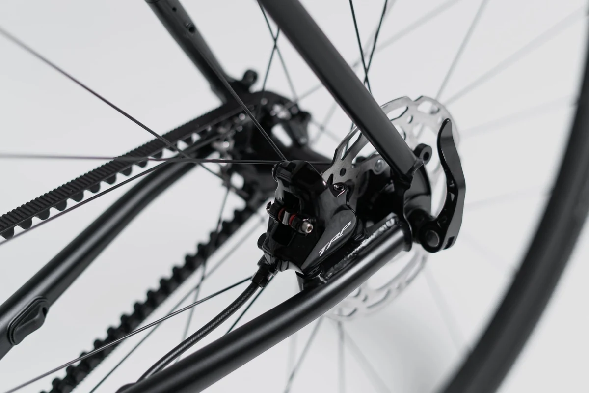 Rear dropout, disc brake and Gates belt of a Booda Bike Atlas seen through the rear wheel