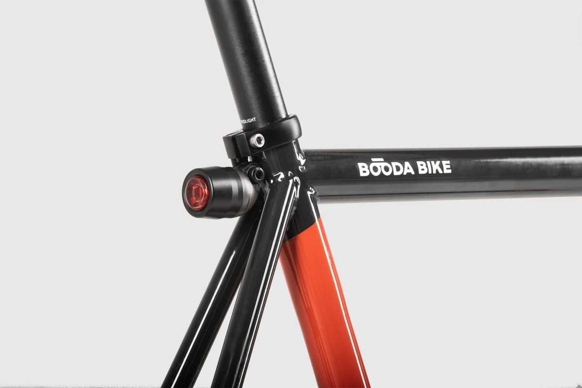 Seat clamp and rear light at the seat cluster of a Booda Bike with an orange seat tube