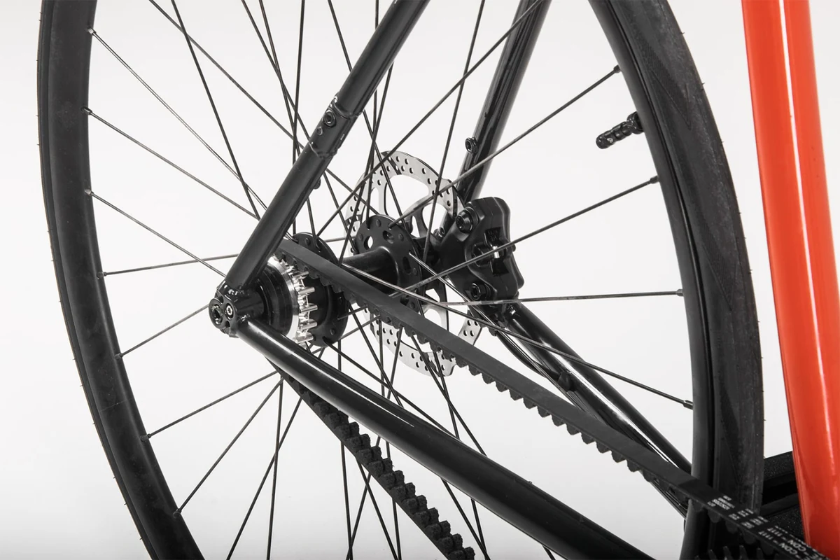 Rear triangle of a Booda Bike with a belt drive and a single sprocket seen through the rear wheel