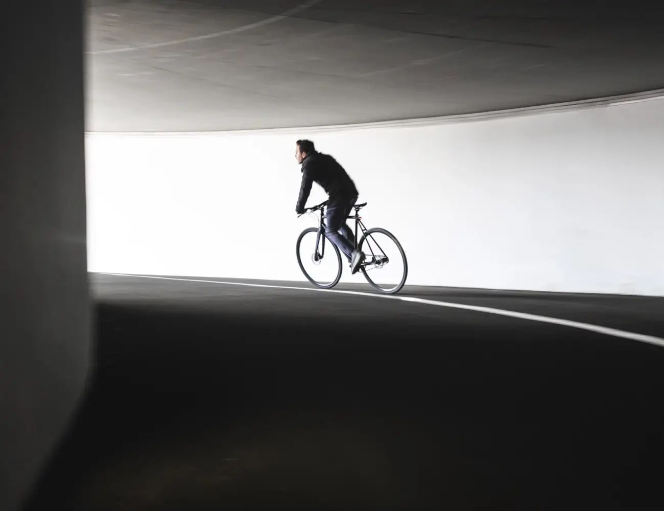 Cyclist riding a Booda Bike single speed bike through a concrete underpass