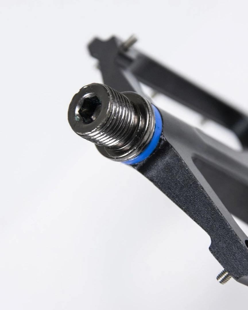 Close-up of the Booda Bike Sport Pedal Alu axle end with a hex socket and a blue ring against the black aluminium body