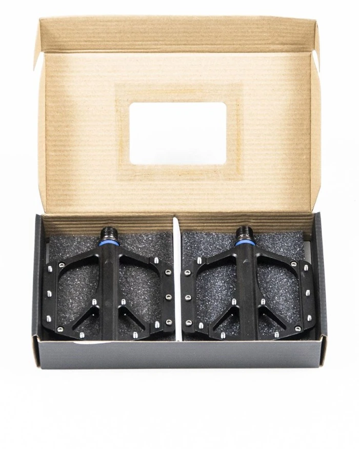 Open cardboard box with a window lid holding the pair of Booda Bike Sport Pedal Alu pedals on dark foam