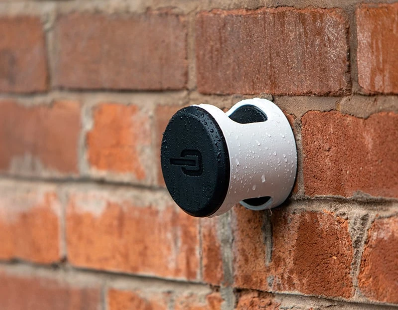 Hiplok ANKR wall anchor fitted to an outdoor brick wall in the rain