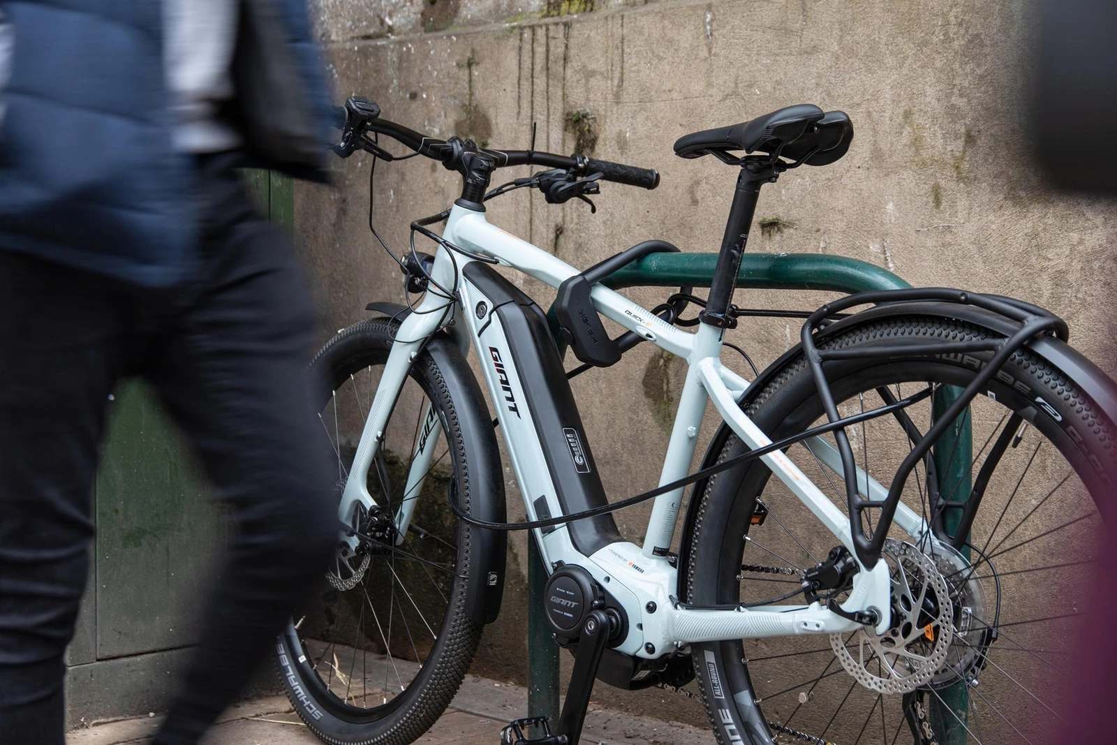 Commuter's e-bike locked to a green railing with the Hiplok DX D lock