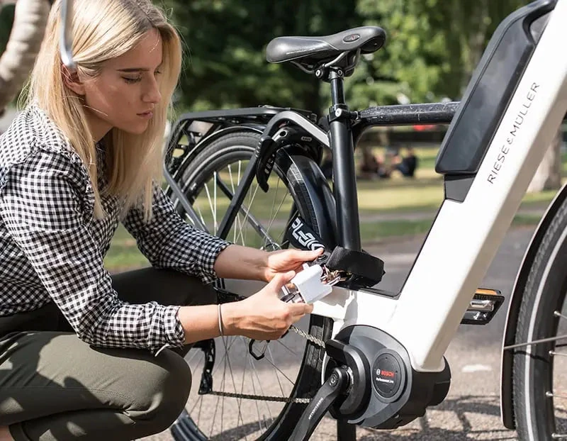 Woman locking an electric bike to a bike rack with Hiplok LITE