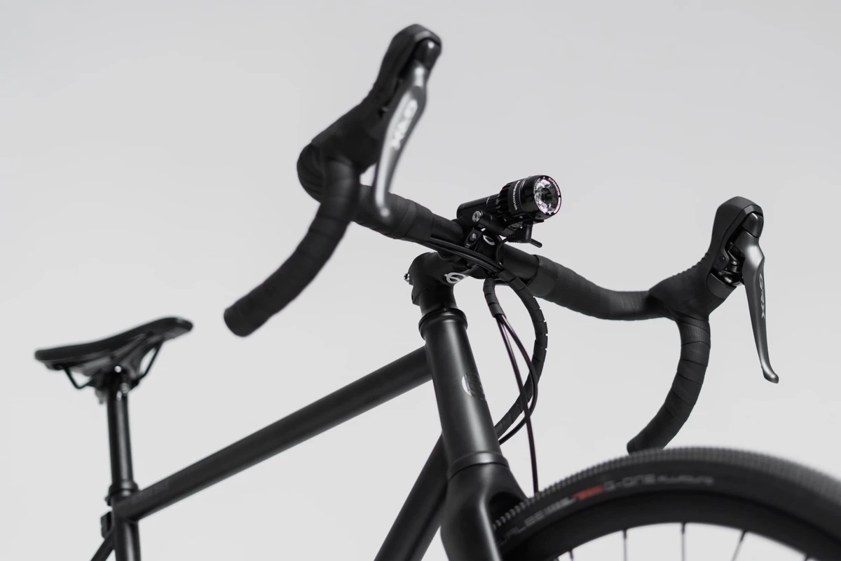 Booda Bike Alpine seen from the saddle side: gravel drop handlebar with bar tape, brake and shift levers and a small front light above the stem