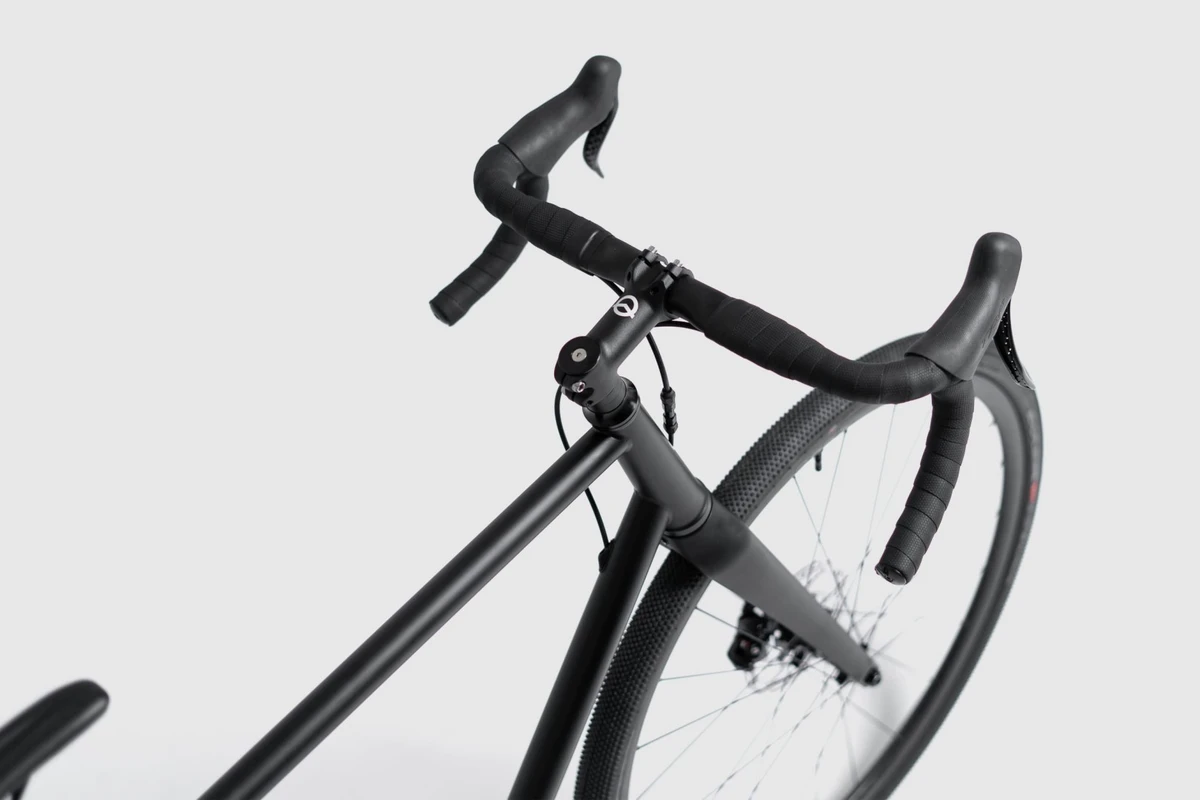 Booda Bike Atlas photographed from above at an angle: aluminium gravel drop handlebar with bar tape, a brake lever and the stem above the front wheel