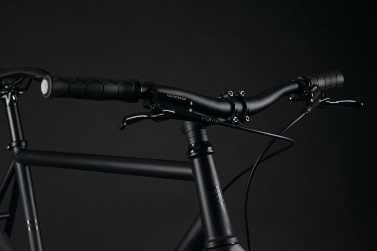 Side view of the Booda Bike Pilot cockpit with a flat handlebar, a Tektro brake lever and a stem above the head tube