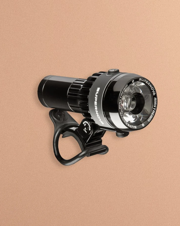 Supernova Airstream 2 with its handlebar mount, seen at an angle on a peach background