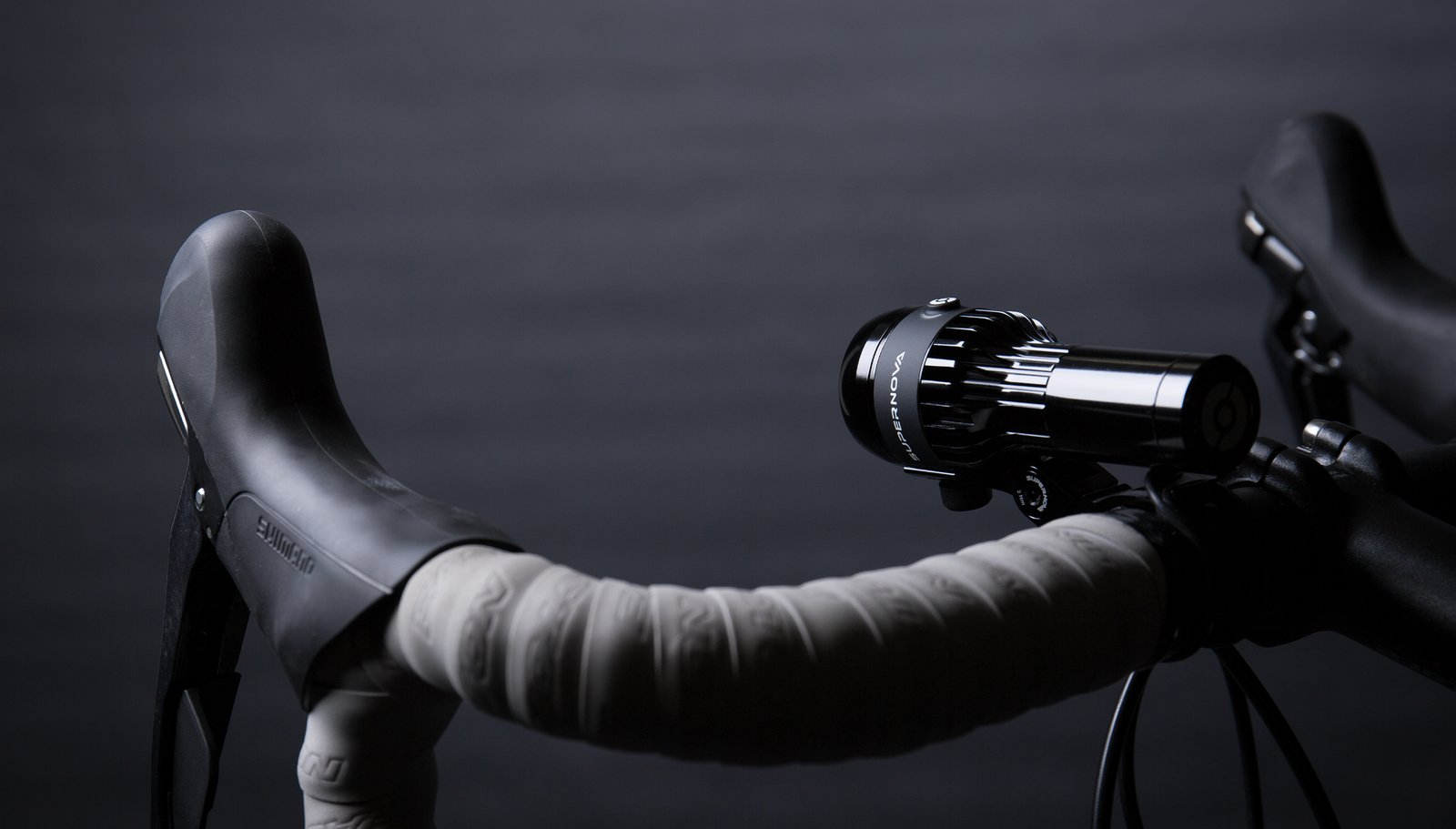 Supernova Airstream 2 mounted on a road bike handlebar with grey bar tape, seen from the side