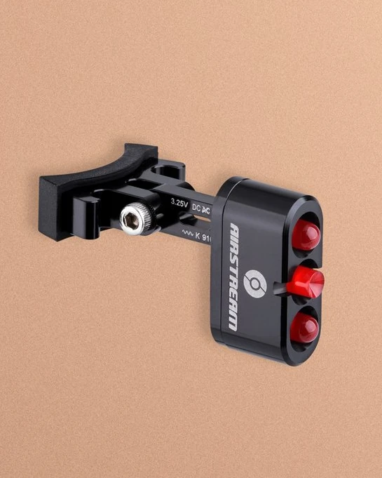 Supernova Airstream Tail Light 2 with seat post clamp and three red lenses on a peach background
